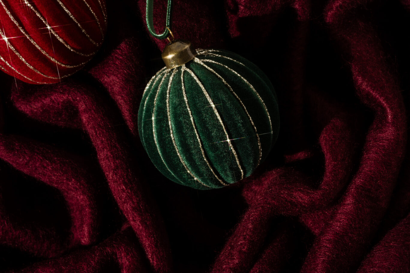 Green and red velvet Christmas ornaments on blanket