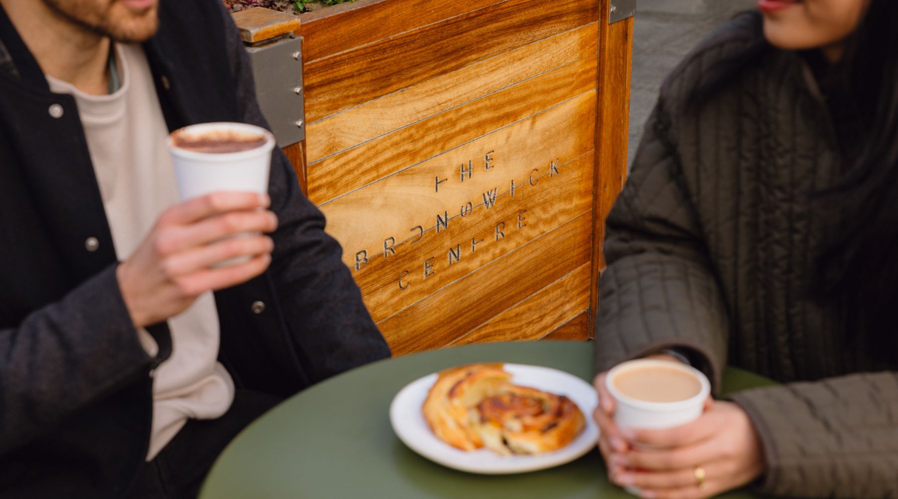 Couple enjoying coffee and pastries at a café outside The Brunswick Centre in Bloomsbury, central London.