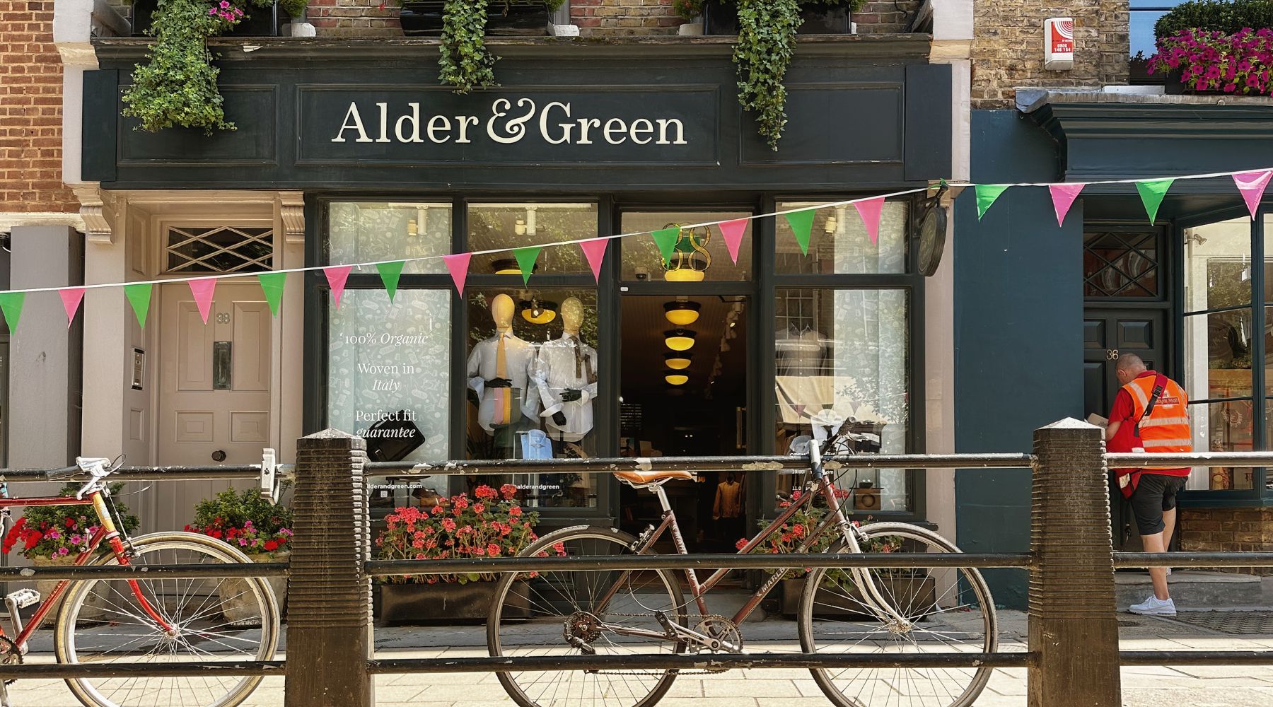 Alder & Green shopfront with bunting, bicycles and flower boxes on a sunny London street.