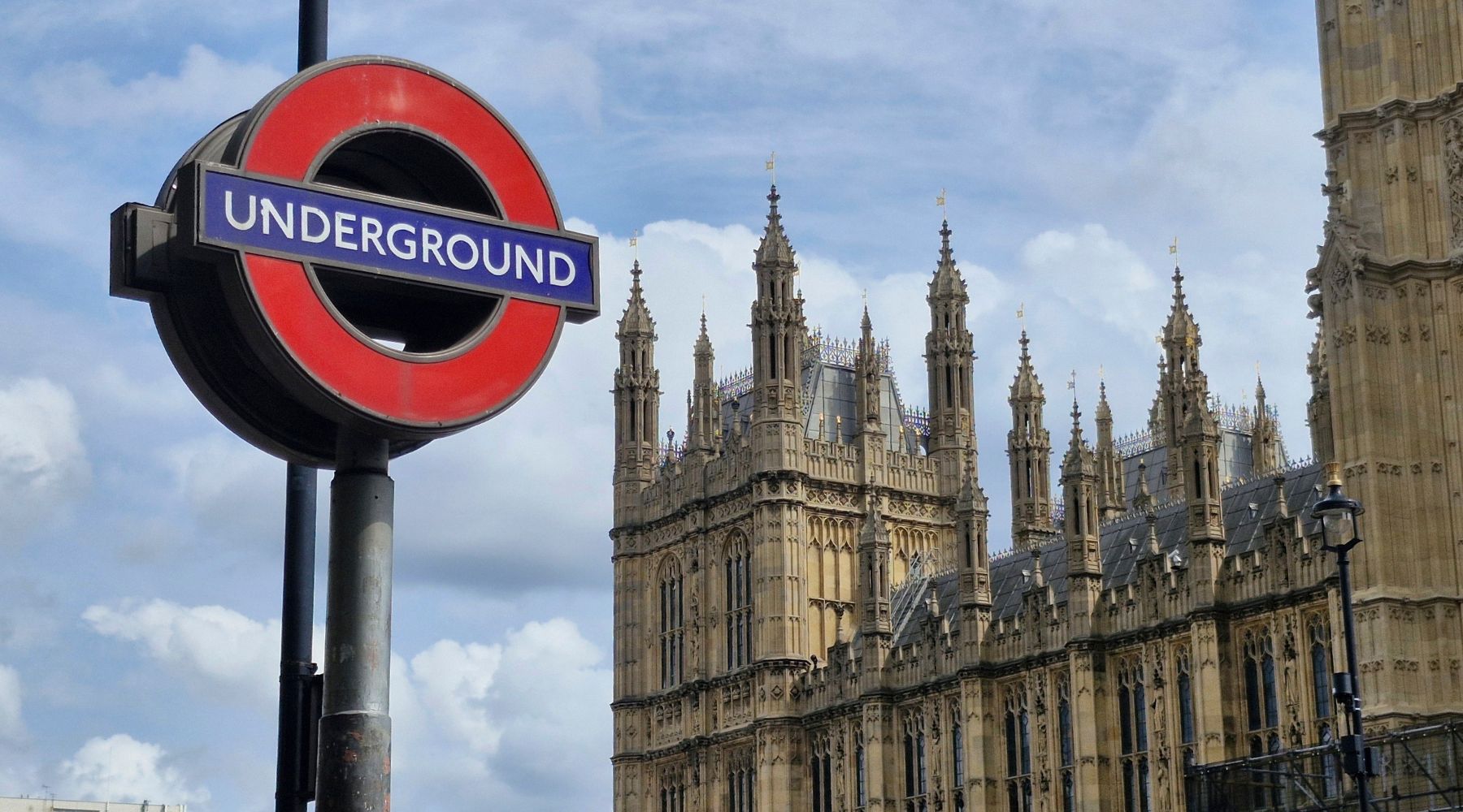 London Underground sign with westminster abbey in the background